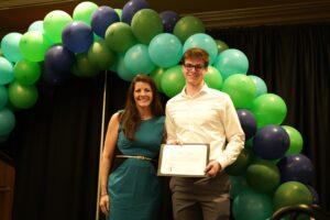 Quinn Sugar with Lauren Mountain holding scholarship certificate